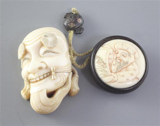 A Japanese ivory noh mask netsuke and an erotic manju ivory and wood netsuke, late 19th / early 20th century, height 4.7cm and 3.3cm